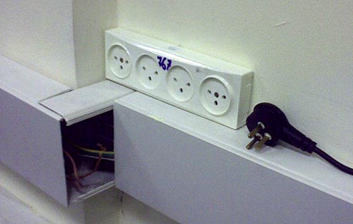 Mains socket strip mounted above a conduit